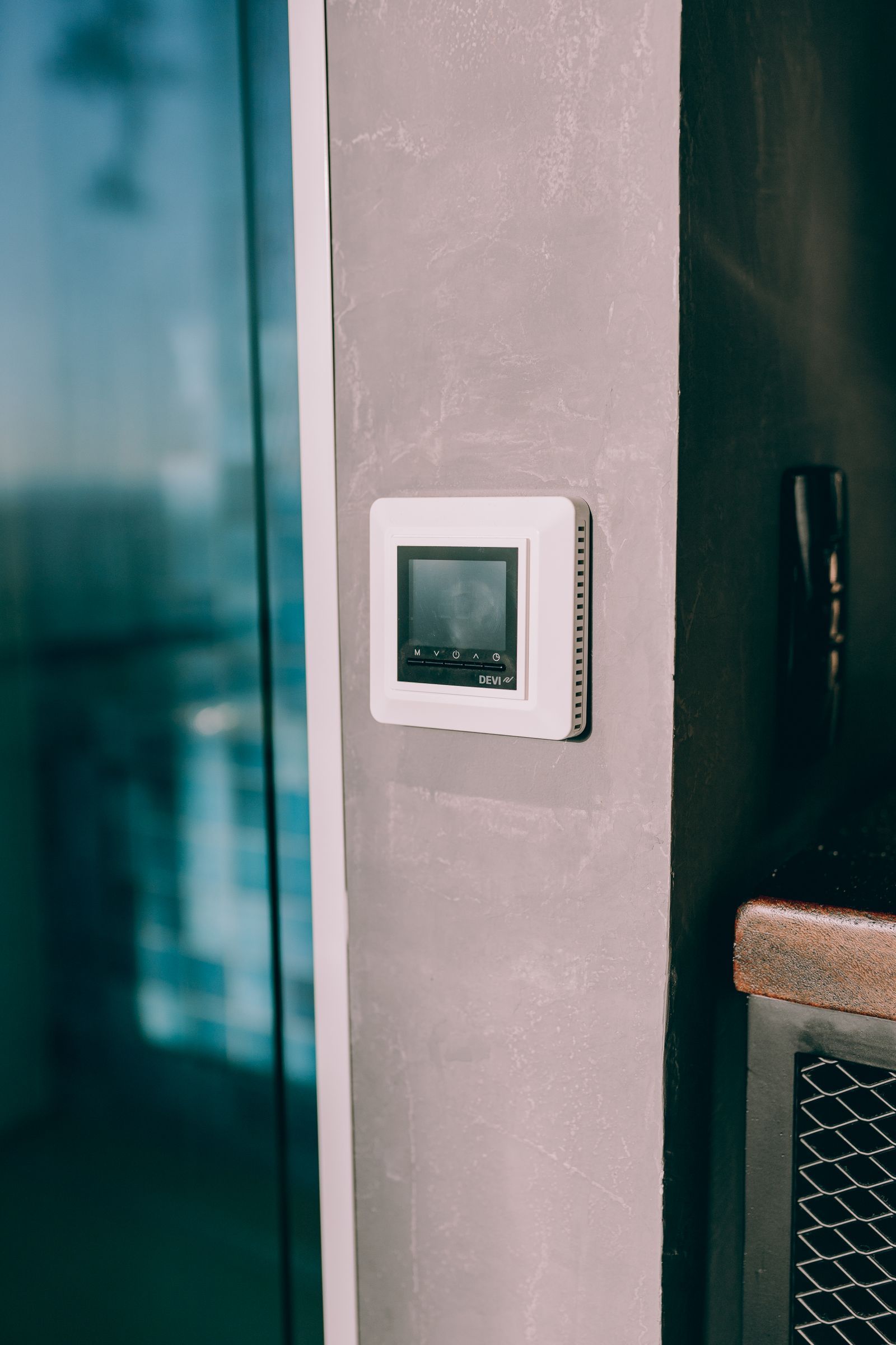 Programmierbarer Raumthermostat an einer Wohnzimmerwand